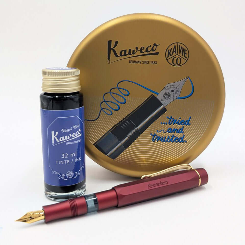 A Kaweco fountain pen in metallic burgundy with a gold nib, displayed alongside a 32 ml bottle of blue ink and a round gold metal packaging on a white background.