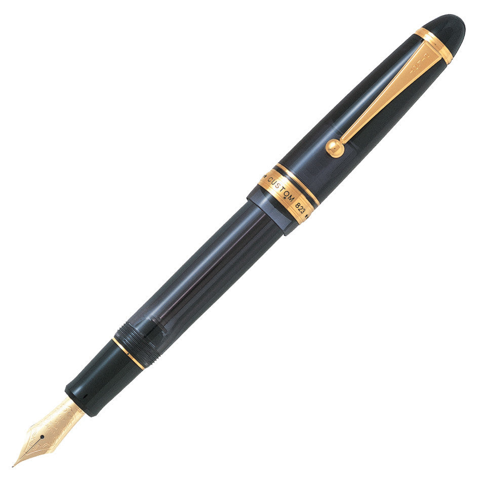 A large translucent amber fountain pen with gold trim, shown uncapped.